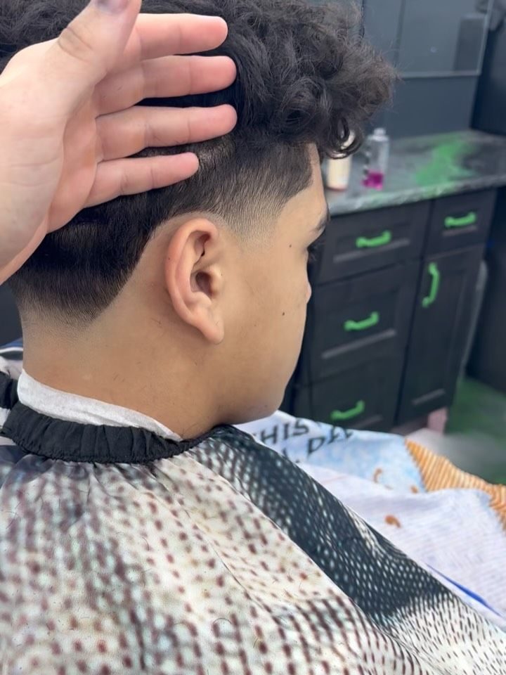 Close-up of a clean taper under curly hair
