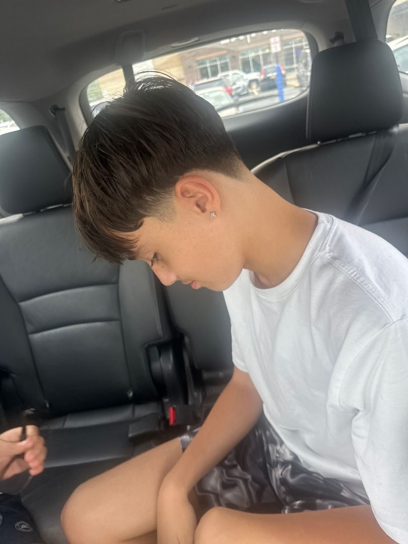 Young client looking down after a fresh cut