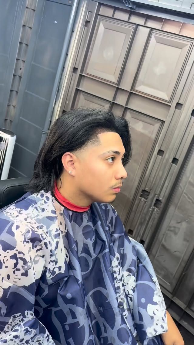 Client with long swept-back hair and a clean taper at the sides